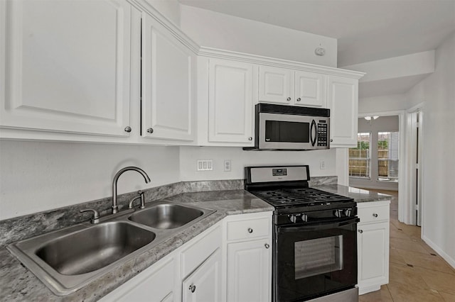 kitchen with black range with gas stovetop, white cabinets, sink, and light tile patterned floors