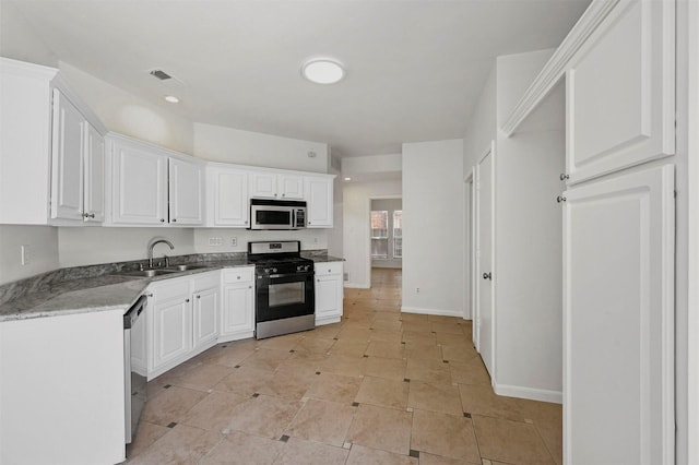 kitchen featuring sink, white cabinetry, light tile patterned floors, and stainless steel appliances