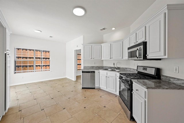 kitchen with sink, white cabinetry, dark stone counters, and appliances with stainless steel finishes