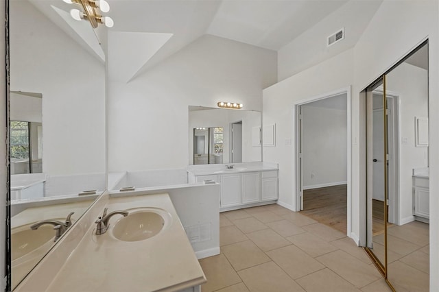 bathroom with tile patterned flooring, lofted ceiling, and vanity