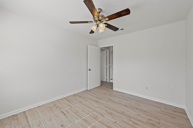 spare room with light wood-type flooring and ceiling fan