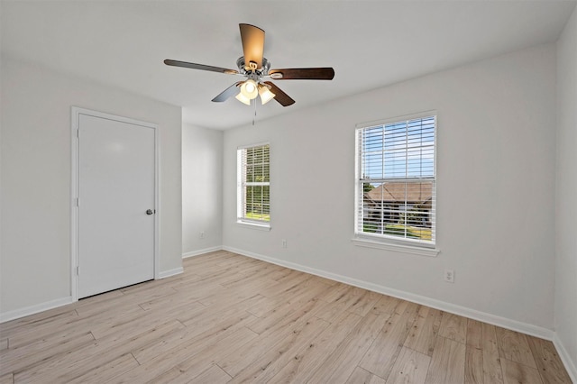 unfurnished room featuring ceiling fan, a wealth of natural light, and light wood-type flooring