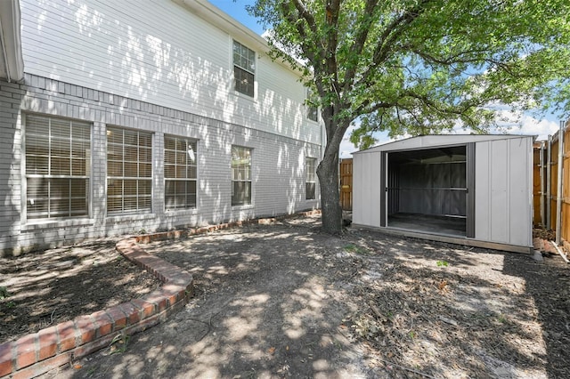 rear view of property featuring a storage unit