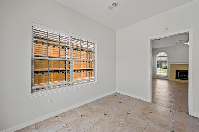 empty room with ceiling fan and light tile patterned flooring