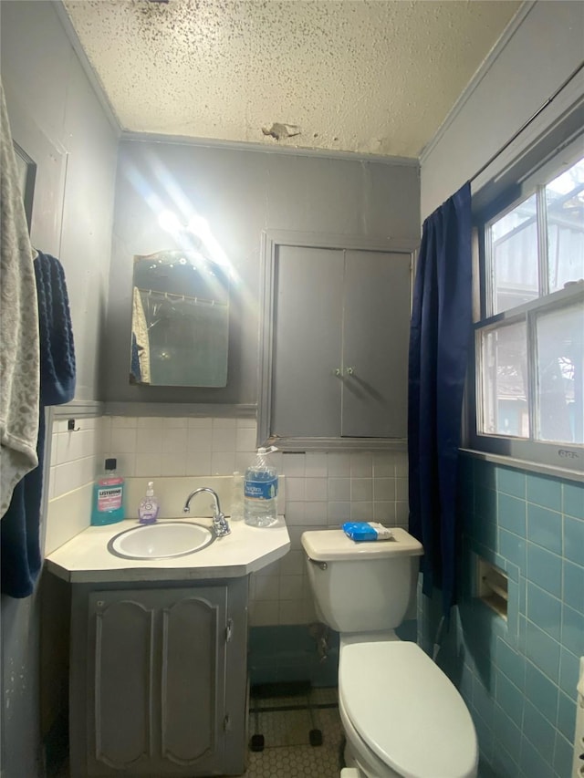 bathroom featuring tile walls, vanity, and toilet