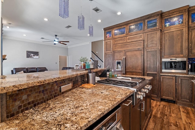 kitchen with glass insert cabinets, visible vents, ornamental molding, and light stone counters