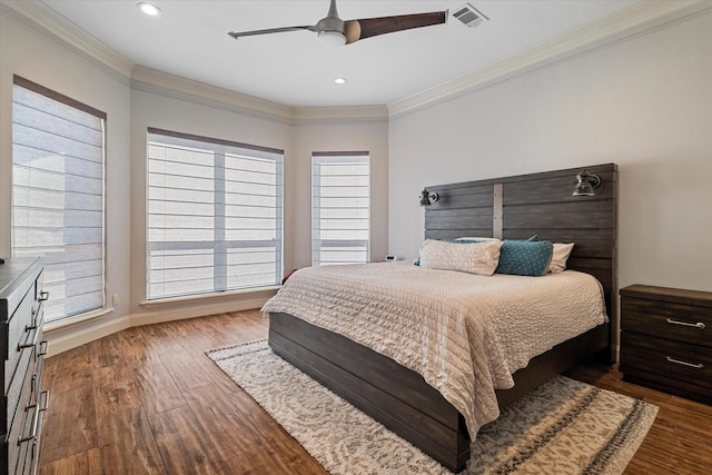 bedroom with ceiling fan, dark wood-style flooring, visible vents, baseboards, and crown molding