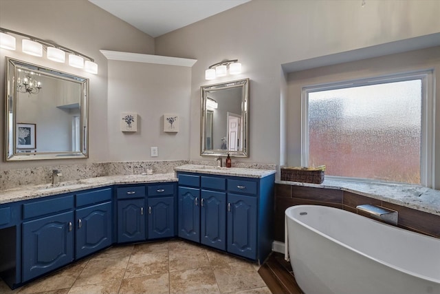 full bathroom with a freestanding tub, a sink, and double vanity