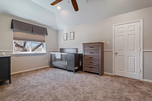 carpeted bedroom featuring vaulted ceiling, ceiling fan, and a nursery area