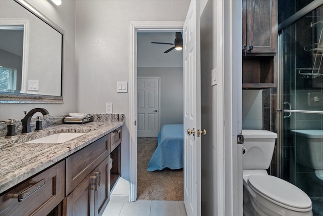 bathroom featuring tile patterned floors, toilet, a shower with door, and vanity