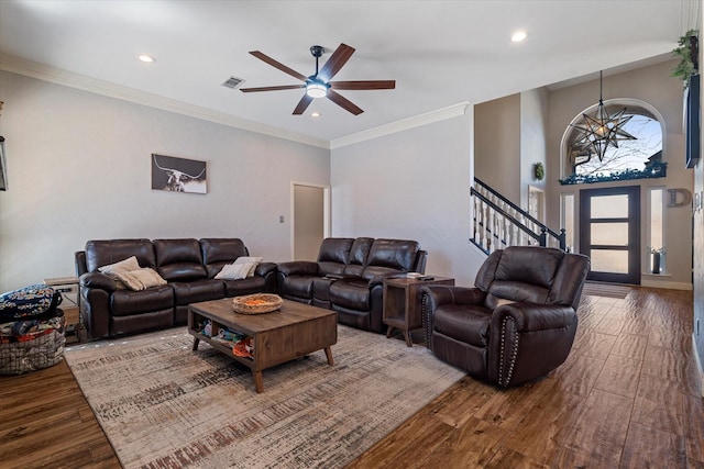 living room featuring wood-type flooring, ceiling fan with notable chandelier, and crown molding