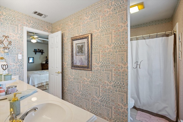 bathroom featuring vanity, ceiling fan, toilet, and walk in shower