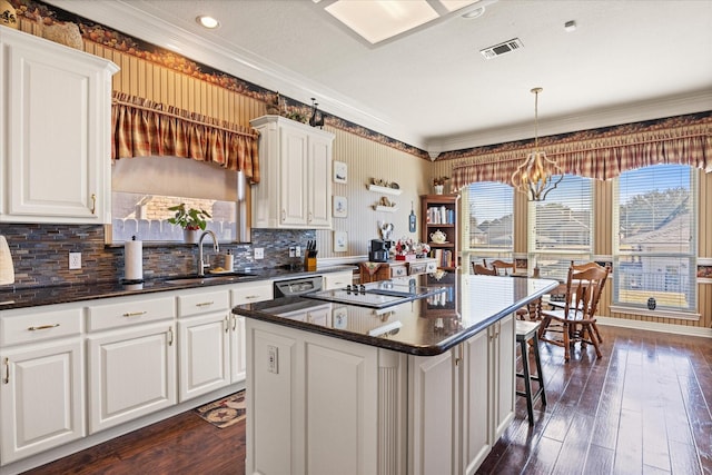 kitchen featuring a kitchen island, white cabinetry, sink, hanging light fixtures, and dark wood-type flooring