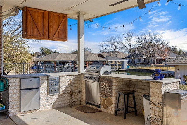 view of patio with a bar, grilling area, area for grilling, and a water view