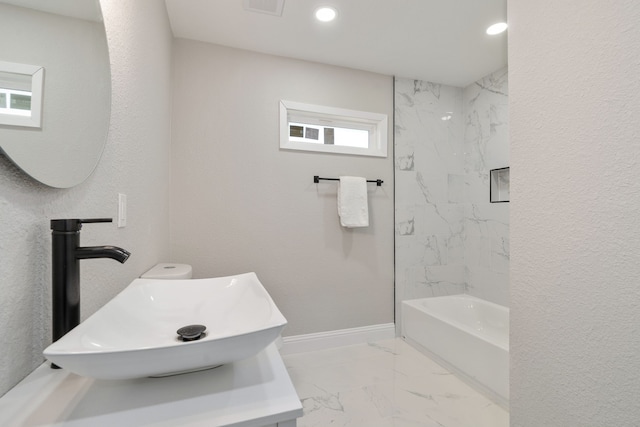 bathroom with tiled shower / bath and sink