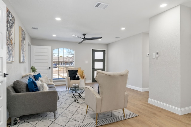 living room featuring ceiling fan and light hardwood / wood-style floors