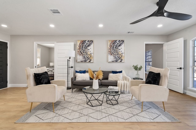 living room with ceiling fan and light wood-type flooring