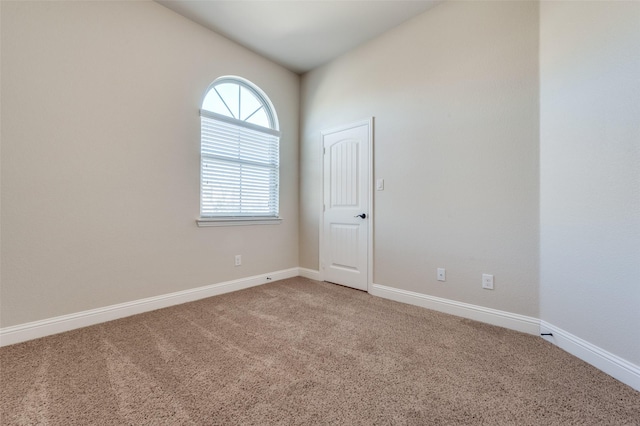 empty room featuring carpet and lofted ceiling