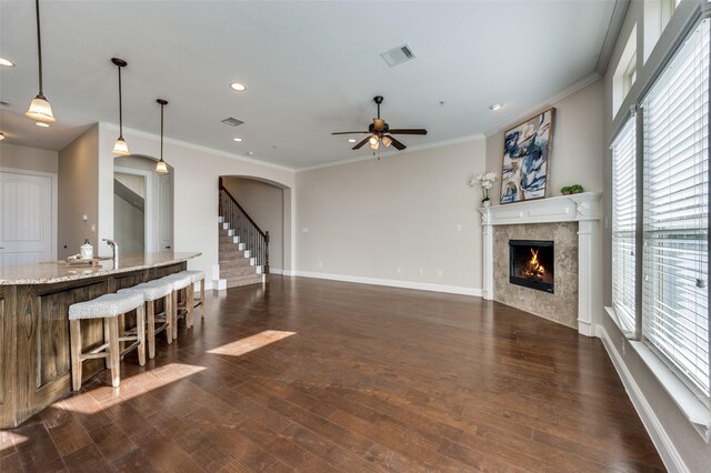 living room featuring dark wood-type flooring, plenty of natural light, and ornamental molding