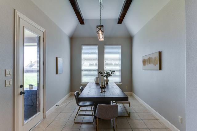 tiled dining area with lofted ceiling with beams