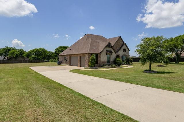 french country style house featuring a garage and a front yard