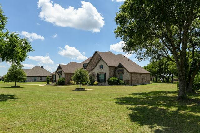 french country inspired facade with a front yard