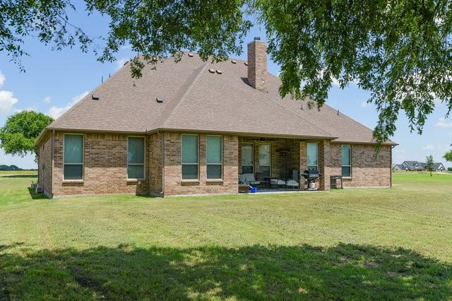 rear view of property with a yard and a patio