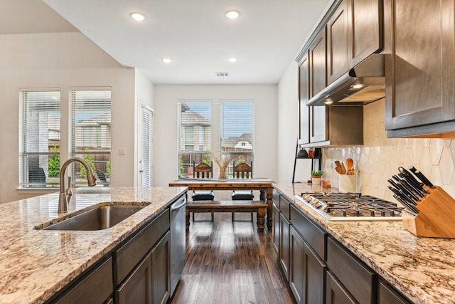 kitchen featuring sink, stainless steel appliances, light stone counters, dark hardwood / wood-style floors, and dark brown cabinetry