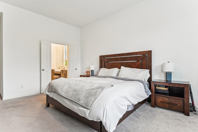 bedroom featuring light colored carpet and connected bathroom