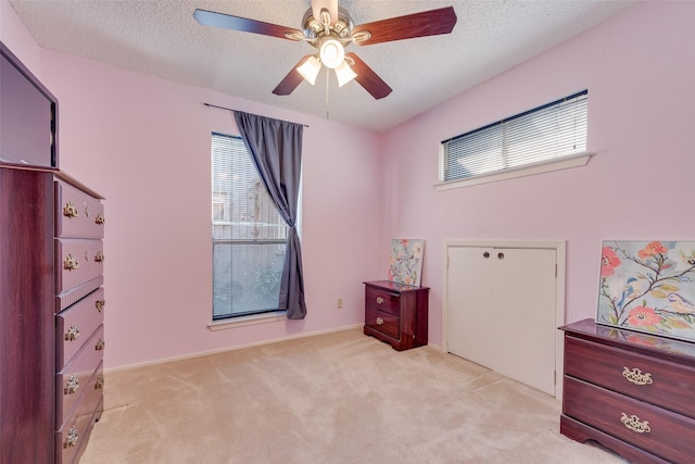 carpeted bedroom with a textured ceiling and ceiling fan