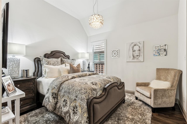 bedroom with vaulted ceiling, a chandelier, and dark wood-type flooring