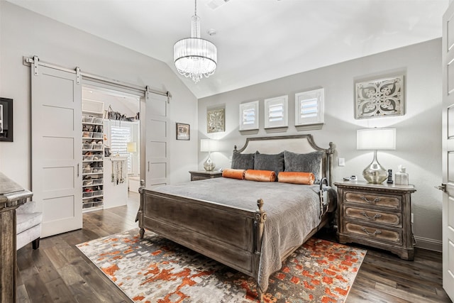 bedroom featuring vaulted ceiling, a chandelier, a barn door, and dark hardwood / wood-style floors