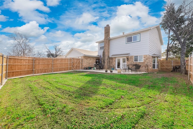 back of property featuring french doors, a yard, and a patio