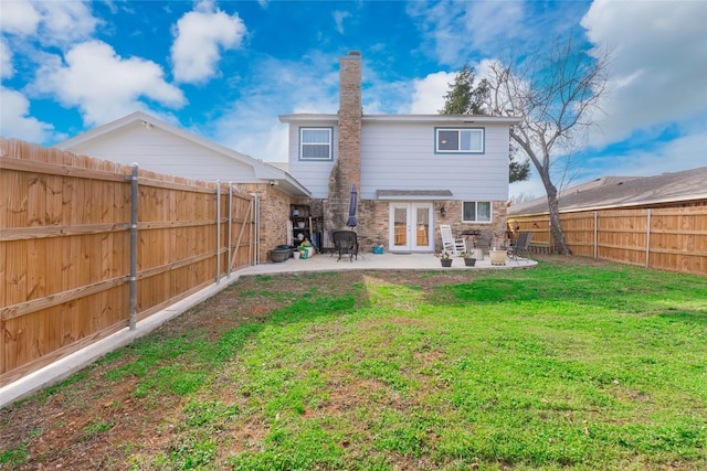 back of house featuring a patio, french doors, and a lawn