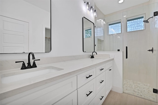 bathroom with a shower with door and vanity