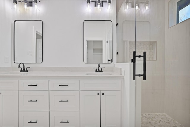 bathroom featuring a shower with shower door and vanity