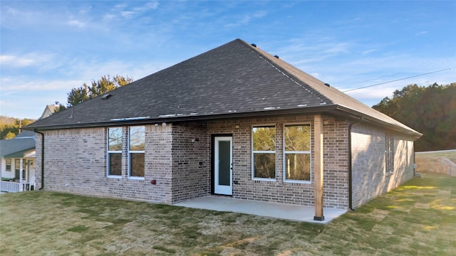 rear view of house featuring a yard and a patio