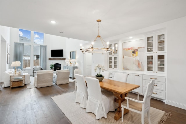 dining area featuring dark wood-type flooring and a notable chandelier