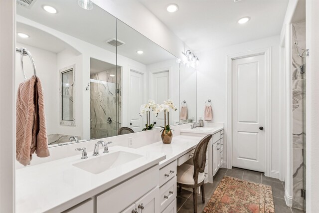 bathroom with tile patterned floors, walk in shower, and vanity