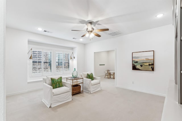 sitting room featuring ceiling fan and light colored carpet