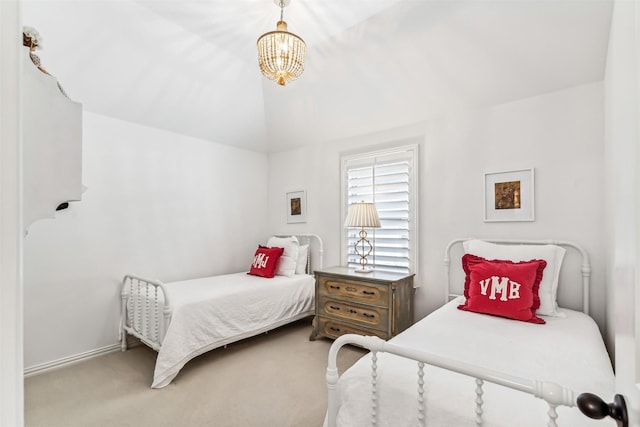 carpeted bedroom featuring baseboards, a chandelier, and vaulted ceiling