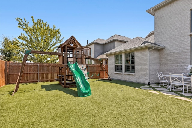 view of playground with a patio area and a lawn