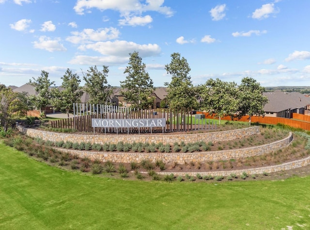 view of property's community with a lawn and fence