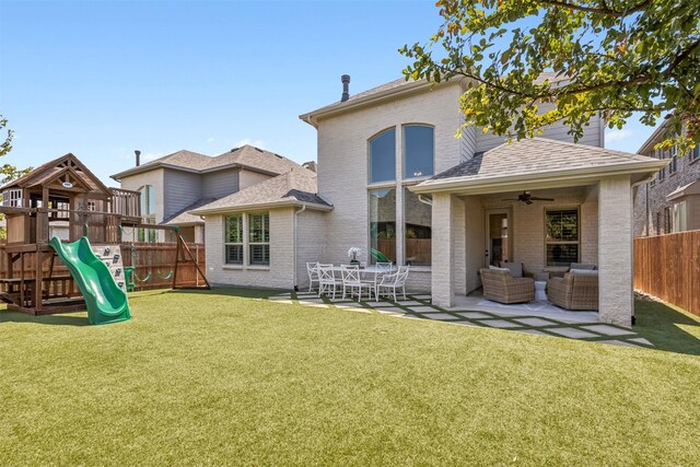 back of property with a playground, a patio, a lawn, outdoor lounge area, and ceiling fan