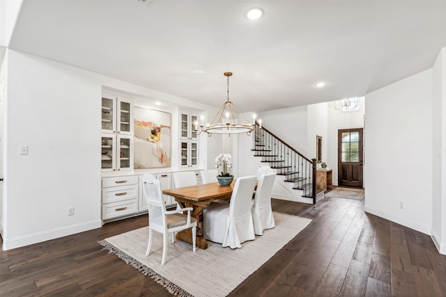 dining room featuring baseboards, stairway, dark wood-style flooring, and a notable chandelier