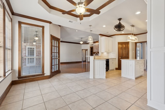 kitchen featuring crown molding, pendant lighting, and an island with sink