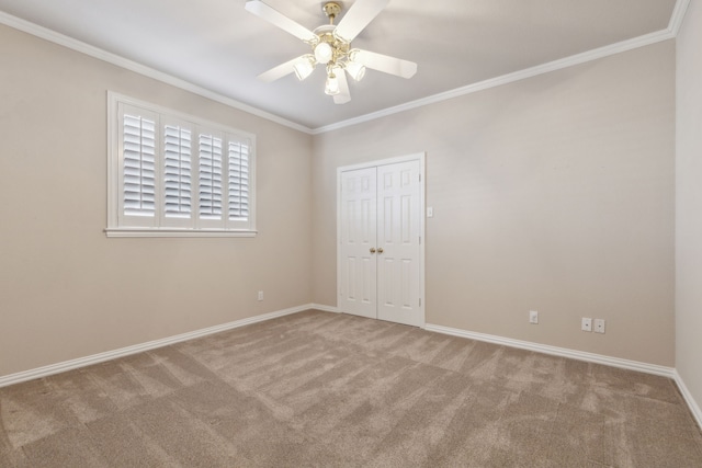 unfurnished room with ceiling fan, crown molding, and carpet flooring