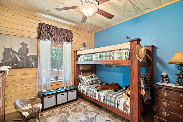 bedroom featuring ceiling fan, wood walls, hardwood / wood-style floors, and wooden ceiling