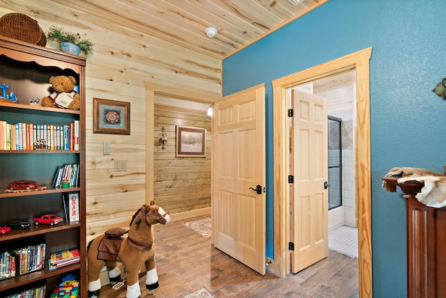 hallway with wood walls, hardwood / wood-style flooring, and wood ceiling