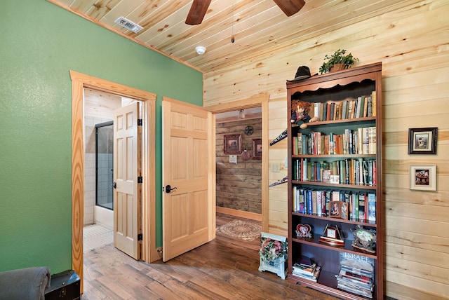 living area featuring ceiling fan, hardwood / wood-style floors, wood walls, and wood ceiling